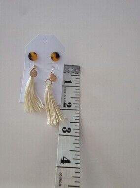These are tortoise shell stud earrings with ivory silk tassels and gold-colored